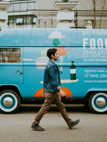 man walking beside van near concrete house